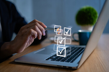 Person Checking Items Off a Checklist on Laptop