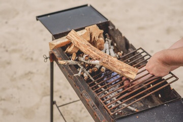 Barbecue grill with firewood on the beach