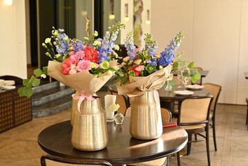 Finished flower bouquets created during the workshop are displayed in a vase.








