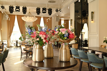 Finished flower bouquets created during the workshop are displayed in a vase.








