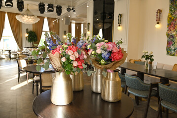 Finished flower bouquets created during the workshop are displayed in a vase.








