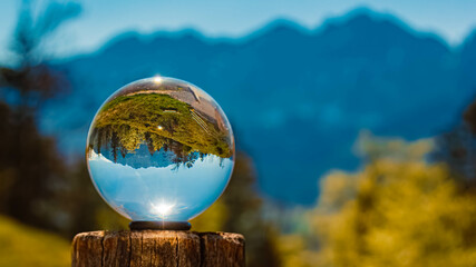 Crystal ball alpine spring landscape shot with Mount Wilder Kaiser in the background at Kaiserlift Kufstein, Tyrol, Austria