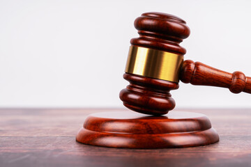 Judge's gavel and wooden pad on table with clear white background