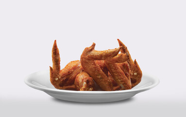 Several pieces of crispy fried chicken wings placed on a white plate.