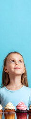 young child enchanted by colorful cupcakes at a local bakery vertical banner - wide skyscraper - blue background