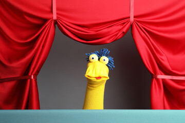 Creative puppet show on stage with red curtains