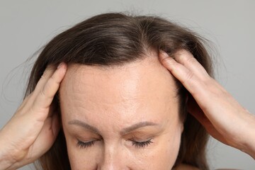 Woman before rejuvenation on grey background, closeup