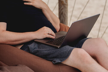 Naklejka premium Man working on laptop on a beach
