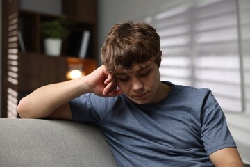Obraz premium Teen problems. Upset teenage boy on sofa at home