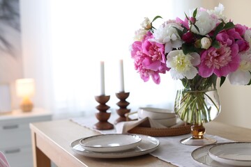 Beautiful table setting with bouquet of peonies in dining room, closeup. Space for text