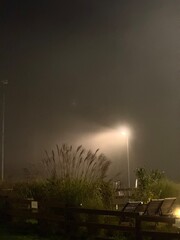 A lone lantern illuminates the foggy area