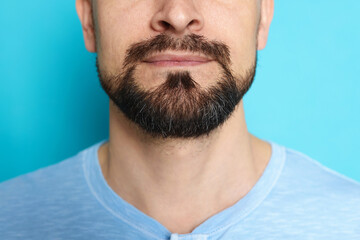 Man before shaving on light blue background, closeup