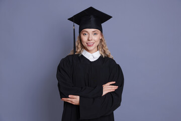 Happy student after graduation on grey background
