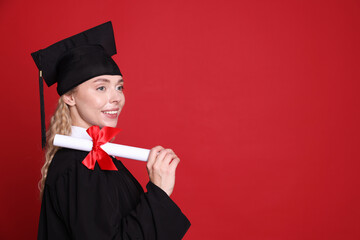 Happy student with diploma after graduation on red background. Space for text