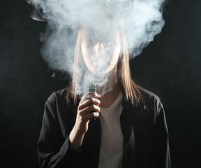 Woman using electronic smoking device on black background
