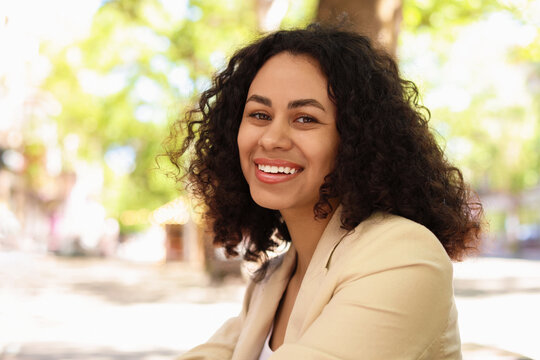 Portrait of smiling Latin American woman outdoors - Powered by Adobe