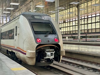A railway station scene with a passenger train ready to depart. Ideal representation of modern public transport and the start of a travel experience.

