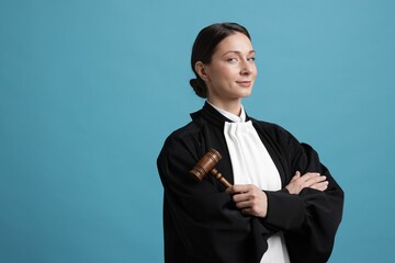 Judge with mallet on light blue background, space for text