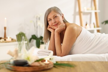 Senior woman relaxing on massage couch in spa salon