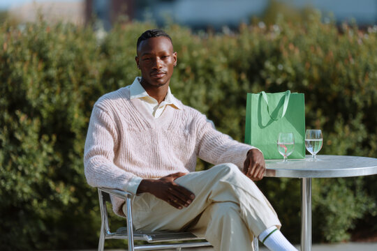 Stylish man relaxing at outdoor cafe after shopping