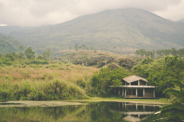 Scenic lakeside house beneath foggy mountains