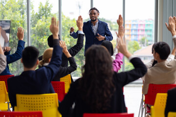 Public speaking training in seminar : African American business man leader in seminar, speaking on business training with group of diverse people company employees in meeting room