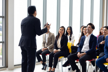 Public speaking training in seminar : Asian business man leader in seminar, speaking on business training with group of diverse people company employees in meeting room