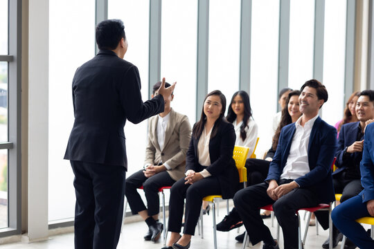 Public speaking training in seminar : Asian business man leader in seminar, speaking on business training with group of diverse people company employees in meeting room