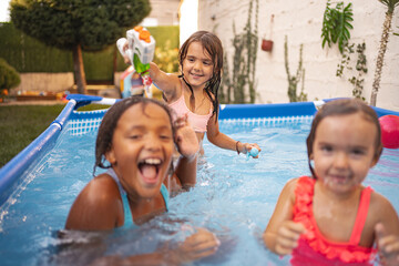 Children having fun in a backyard pool on a sunny afternoon