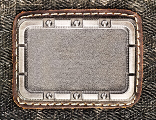 Photo of metal badge, tag or label on denim cloth surface.