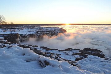 Fog envelops ocean waves at dawn creating a mystical atmosphere