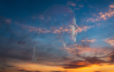 Double exposure of young woman and sunset sky.