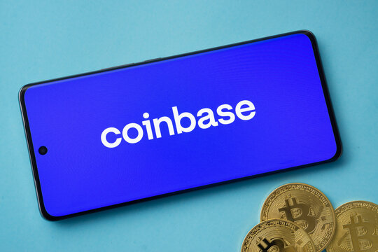 Dhaka, Bangladesh- 17 June 2025: Smartphone displaying Coinbase logo with Bitcoin coins on a blue background.