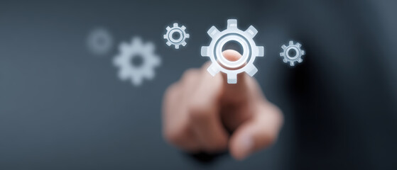 Hand interacts with floating digital gears, symbolizing technology and innovation