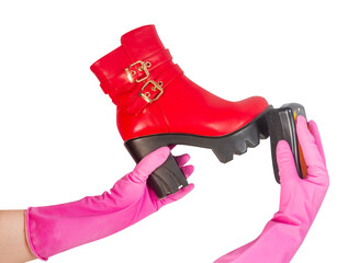 Isolated photo of woman hands in gloves cleaning red leather high heeled woman boots on white...