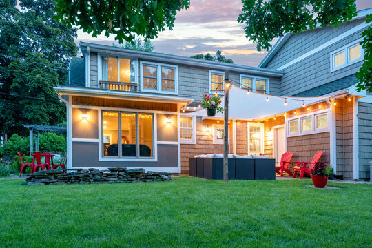 Beautiful restored Cape Cod style house exterior patio. at dusk