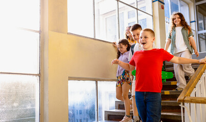Excited school kids running through hallway.