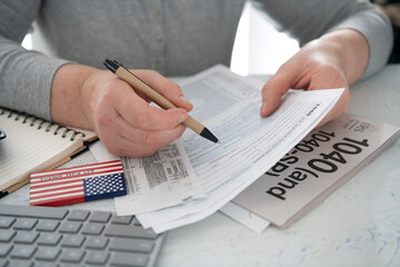 Tax deduction planning concept. Woman filling out tax form 1040.