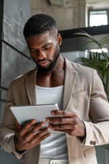 Stylish African American Man Using Tablet Modern Beige Suit Serious Expression Digital Technology Business Professional Entrepreneur Modern Office Workplace Technology Gadget Digital Device Screen    