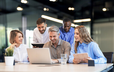 Five business professionals using laptop on desk discussing strategy company.