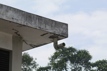  Old Concrete Roof Corner with Exposed Drainpipe and Water Damage