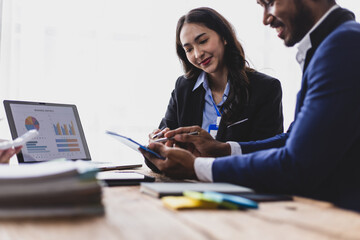 Group of Asian business people looking at document during meeting. Business people having a meeting in the office, brainstorming and working together.