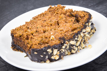 Pastry made of zucchini with nuts and raisin on plate. Delicious dessert