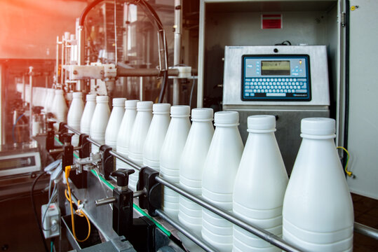 White plastic milk bottles on the conveyor on a modern dairy plant