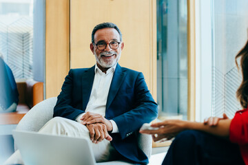 Senior businessman smiling during a meeting in a modern office setting