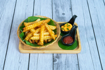 French fries with ketchup on wooden background.