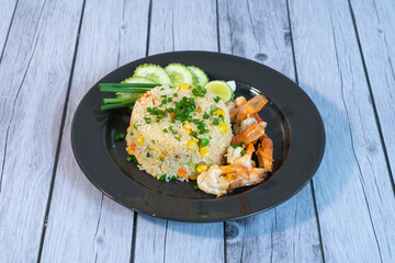 Fried rice with shrimp on the white dish on wooden table
