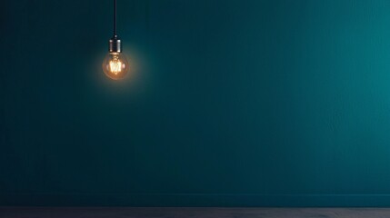 Vintage light bulb hanging against a textured blue wall.