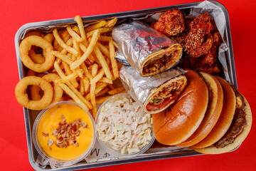 American food set - burger, french fries, shawarma, chicken wings, cheese sauce, onion rings and cole slaw