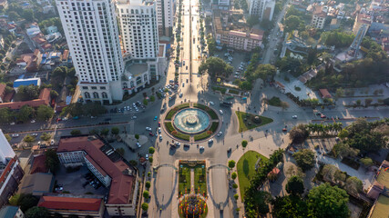 Backlit aerial view of Thai Nguyen city's central roundabout, with long shadows and sun glare,...
